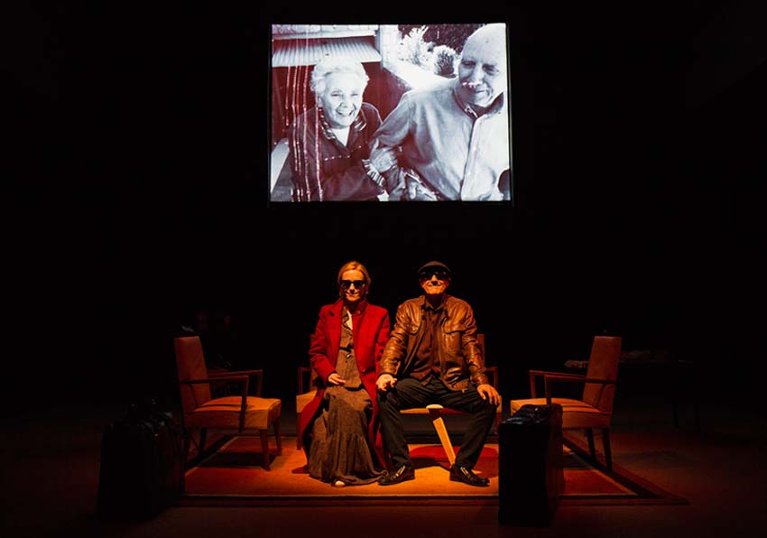 A couple sitting on a chair and the image of an older couple above them